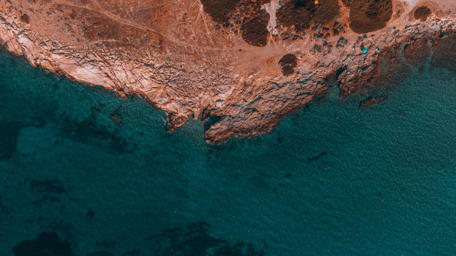 The rocky coast and clear water of Sounion on the Athens Riviera, Greece