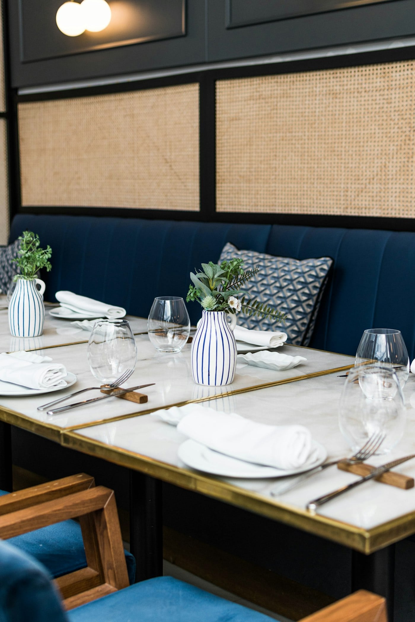 An elegant restaurant table set with white plates, glassware and flowers