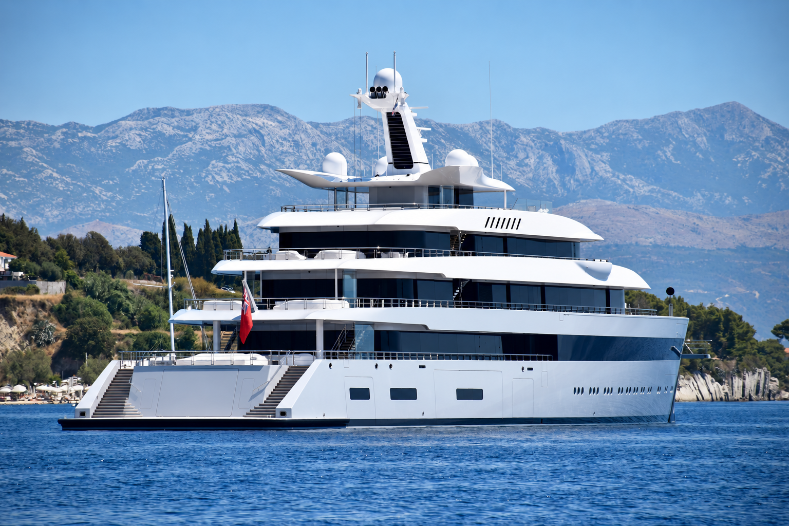 A white superyacht with empty decks on blue Mediterranean water